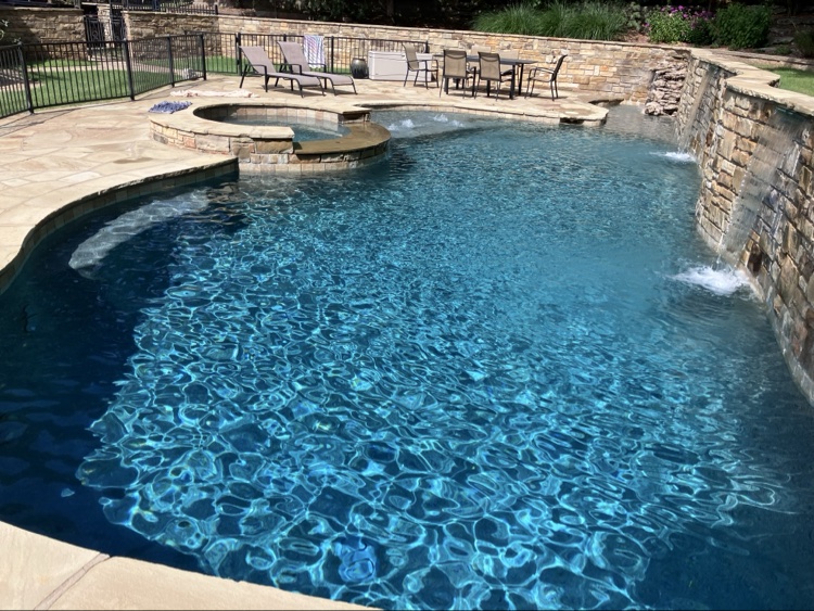 Backyard pool with stone waterfall and spa